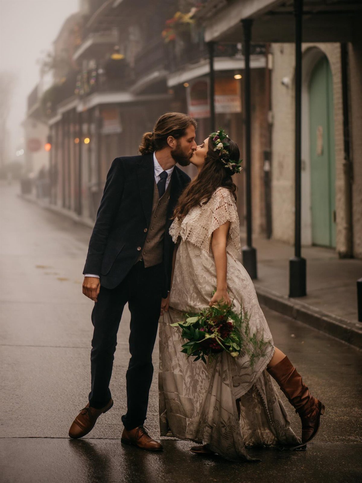 Bride and groom kissing on a foggy street with historic New Orleans architecture.