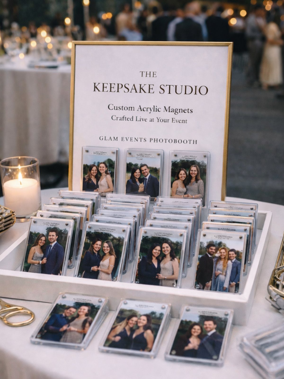 Acrylic photo magnets displayed in a white tray next to a gold-framed sign.